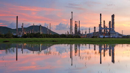 Fototapeta premium Industrial view of oil refinery factory with water reflection at sunrise, In the east of Thailand
