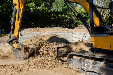 Fototapeta premium mechanical excavator in action on a construction site of a house