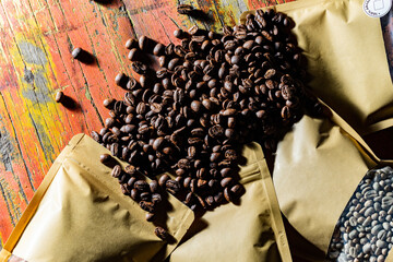テーブルの上に散らばるコーヒー豆とコーヒーの袋