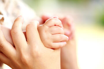 母親と赤ちゃんが手をつなぐ　両手を握って親子の触れ合い