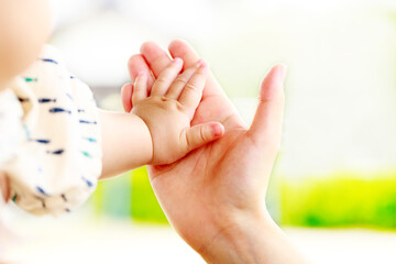 母親と赤ちゃんが手をつなぐ　親子の触れ合い