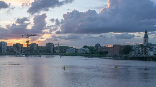 Time lapse of clouds at sunset over river bank town