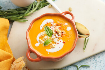Tasty pumpkin cream soup in pot on table