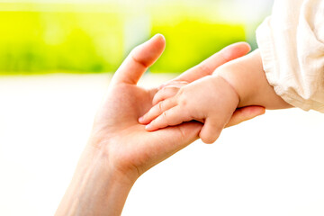 母親と赤ちゃんが手をつなぐ　親子の触れ合い
