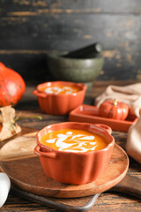 Tasty pumpkin cream soup in pot on table