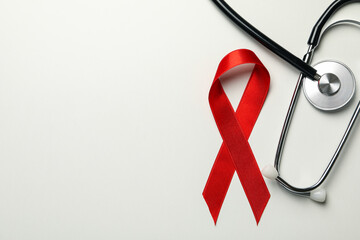 Red awareness ribbon and stethoscope on white background - obrazy, fototapety, plakaty