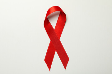Red awareness ribbon on white background, close up