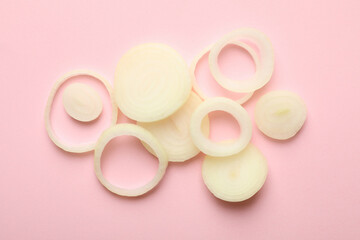 Fresh onion slices on pink background, top view