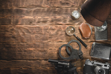 Spy detective agent equipment and accessories on the wooden desk background with copy space.