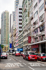 Taxi transportation in Hong Kong with typical urban decay residential and office buildings and busy...
