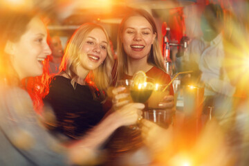Female friends enjoying wine in night club. High quality photo - obrazy, fototapety, plakaty