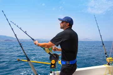 blue sea fisherman in trolling boat with downrigger