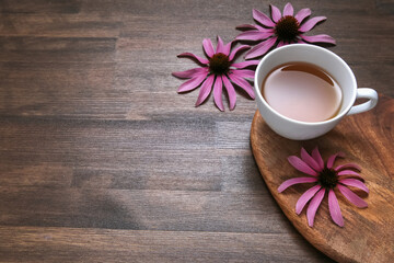 Fototapeta na wymiar echinacea flowers on wooden background with tea
