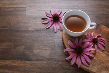 echinacea flowers on wooden background with tea