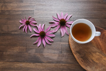 echinacea flowers on wooden background with tea