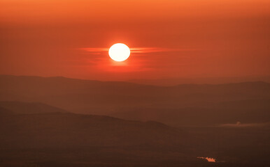 Orange sunset with the sun at the horizon setting down