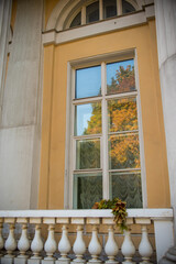 Fototapeta na wymiar yellow leave on the porch and the window in the old building 
