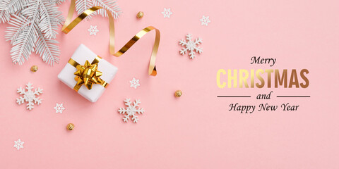 Fototapeta na wymiar Christmas gift, golden decorations on pastel pink background