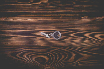 Studio photo of one broken key on a wooden background.
