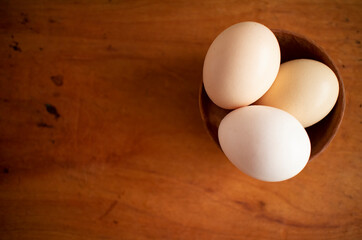 Three fresh white eggs in a wooden cup on a wooden table
木製テーブルの上にある木のカップに入った３つの白い卵 5