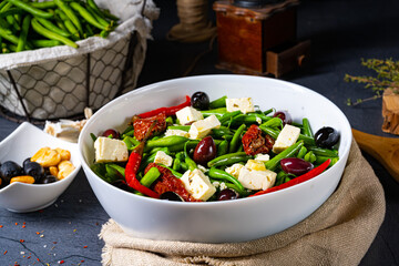 Spicy green bean salad with olives, feta cheese and dried tomatoes