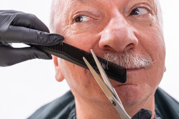 Senior man during moustache grooming process
