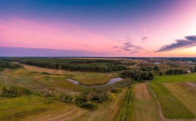 Rural landscape in the evening with a beautiful burning sky, aerial view. Panoramic view of the countryside during sunset