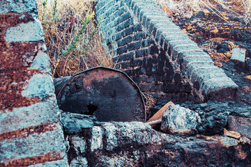 Viejo barril oxidado y abandonado entre dos muros - obrazy, fototapety, plakaty