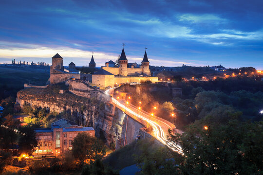 Panoramic  night view of ancient fortress castle in Kamianets-Podilskyi, Khmelnytskyi Region, Ukraine. Old ?astle photo on a postcard or cover. Long exposive