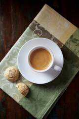 Cup of coffee with amaretti (Italian biscuits) on rustic wooden background. Top view. 
