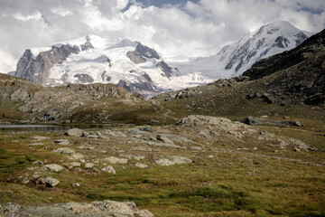 Fototapeta na wymiar White snow covered mountain on a cloudy summer day in Switzerland near Gornergrat. 