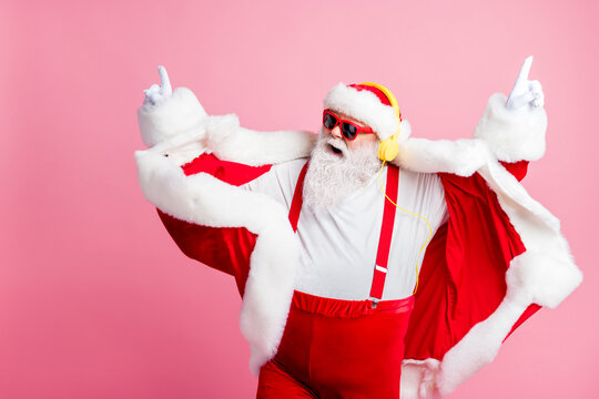 Photo crazy funky cool beard santa claus enjoy listen stereo volume music headphones holly jolly newyear x-mas christmas songs wear pants suspenders sunglass isolated pastel color background