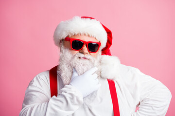 Photo pensive unsure santa claus touch hand his beard think thoughts decide best way x-mas christmas gift present delivery wear overalls sunglass white gloves isolated pastel color background