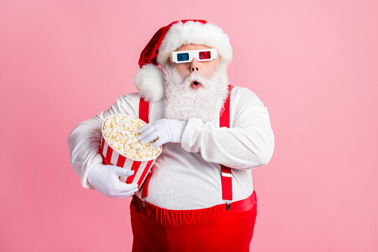 Portrait of his he nice attractive focused amazed funny bearded fat Santa watching film eating fast fastfood corn spending free time pastime isolated pink pastel color background