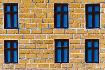 Fototapeta na wymiar background from a miniature houses in a city park, yellow brick wall and windows