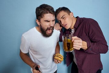 Two cheerful drunk friends drinking beer lifestyle emotions on a blue background