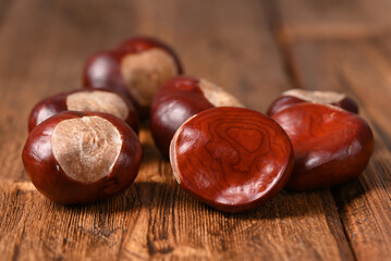 Raw chestnuts on a wooden table.