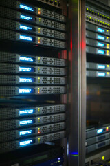 Close up of server rack cluster in huge data center room. Security in  data storage. Backup, mining, hosting, mainframe, farm, cloud and computers. 