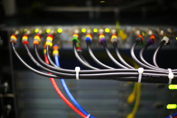 Colorful electric cables. Installing electrical cables into broadcasting equipment and power supply boxes. Hardware for TV broadcasting. Satellite business. 