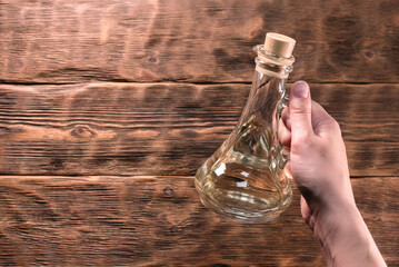 Bottle with cooking oil on the wooden kitchen table background.