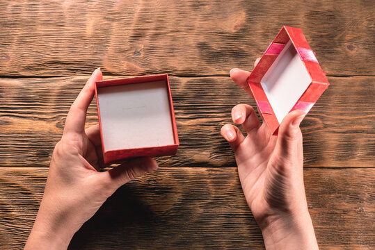 An Open Empty Gift Box And Female Hands On The Wooden Table Background. No Gift Concept.