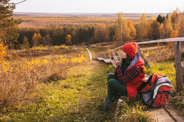 woman is resting in the autumn forest. Fall mood to travel. Colorful beautiful natural landscape....