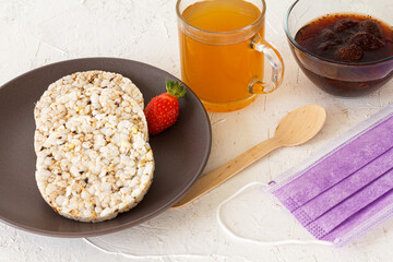 Puffed rice cakes and strawberry on the plate with a cup of tea