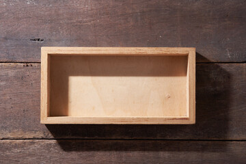 Top view of empty wood crate on wooden background