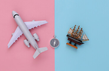 Minimalism travel, adventure flat lay. Compass and ship, air plane on blue-pink pastel background. Top view