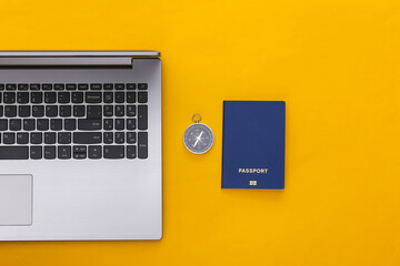 Flat lay vacation holiday and travel planing concept. Laptop and passport, compass on yellow background. Top view