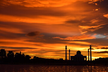 Fototapeta na wymiar Sunset view with beautiful golden sky At Masjid in the middle of Songkhla Province, the colorful sky lights in the evening