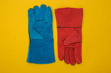 Blue and red Work gloves on yellow background. Top view