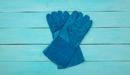 Work gloves on blue wooden background. Top view