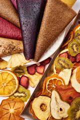 Close-up dried fruits in craft paper box and fruit pastille in white plate